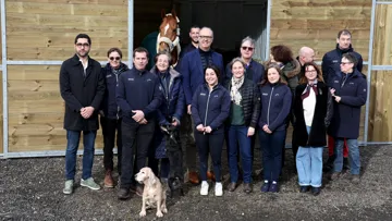Les participants à cette rencontre posent devant l’écurie temporaire construite grâce au soutien de la Fédération française de la maroquinerie et de Cheval Liberté.