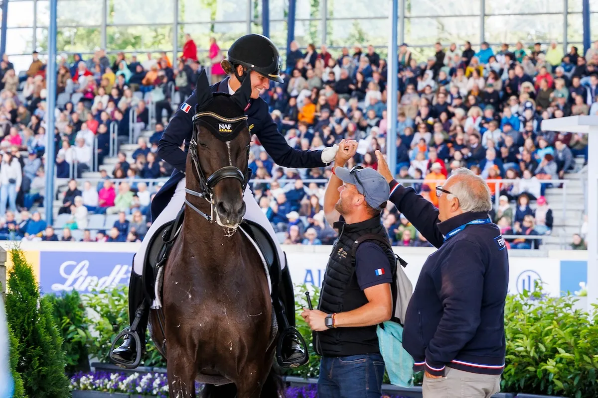 Pauline Basquin en sortie du Grand Prix Libre à Aix-la-Chapelle après avoir établi un nouveau record de France, félicitée par son groom, Rodrigue, et le sélectionneur national, Jean Morel.