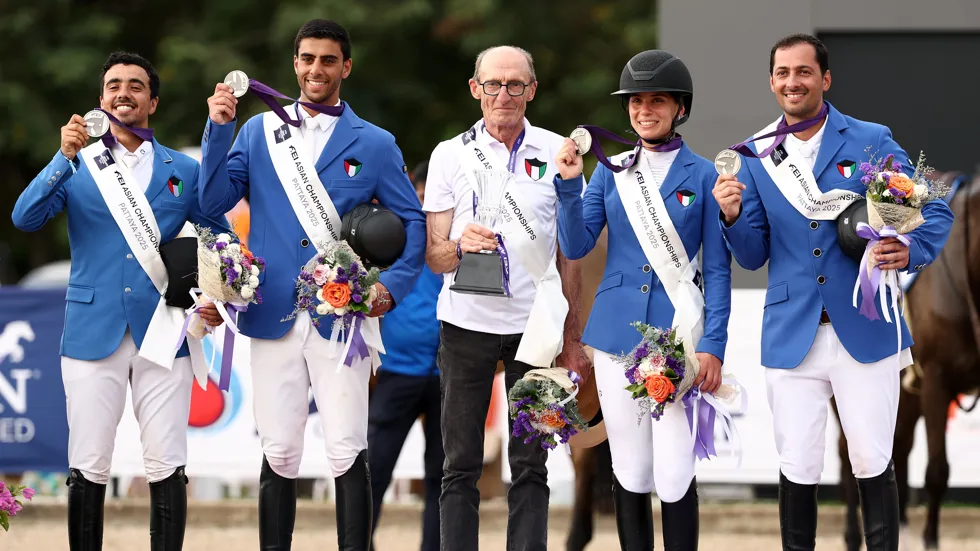 Peter Postelmans op het podium met zijn team van Koeweit