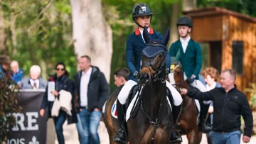 Énigme des Prés aux côtés de sa cavalière, Brune Faivre, avant l'entrée en piste.