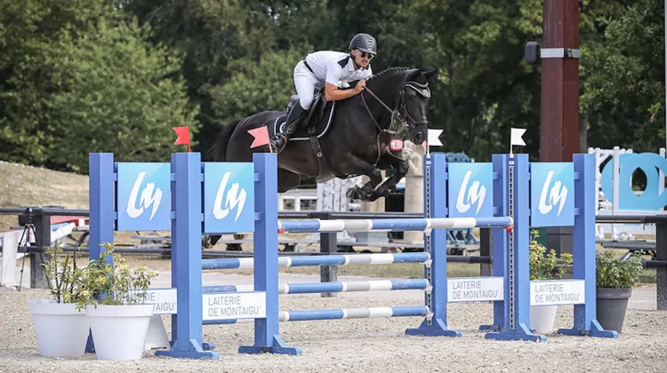 Paul Barret en selle sur Qualified Van T Huka lors des Championnats de France AS Jeunes Cavaliers.