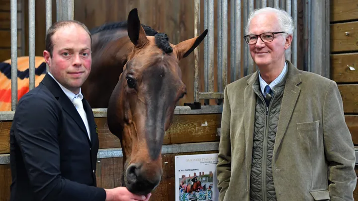 Brice Brassart pose aux côtés de Catchar Mail et son propriétaire et éleveur, Bernard Le Courtois, lors du salon des étalons de Saint-Lô, en février 2026.